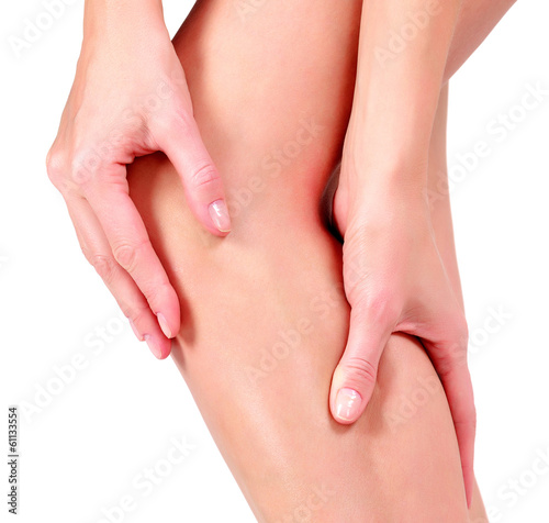 Photo: Woman holding sore knee, on white background Woman holding sore knee, on white background