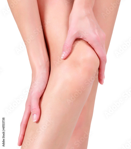 Photo: Woman holding sore knee, isolated on white background Woman holding sore knee, isolated on white background