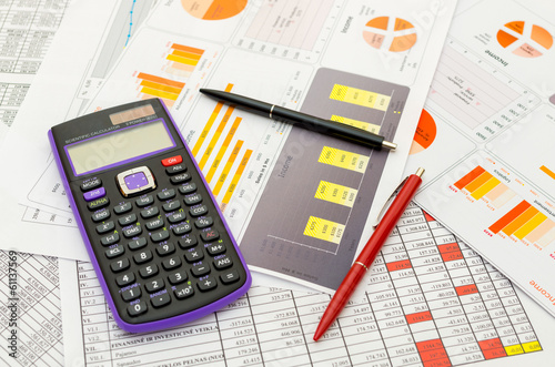 Photo: Calculator and pencil on the paper with financial graph's Calculator and pencil on the paper with financial graph's