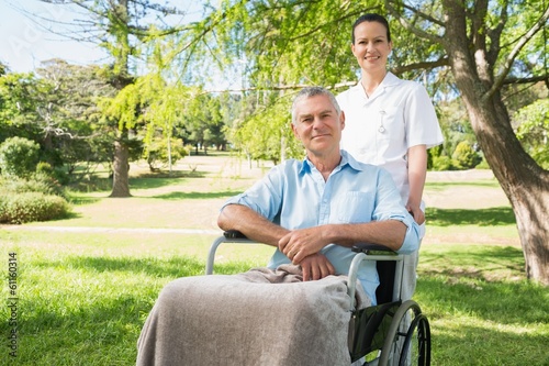 Photo: Woman with her father sitting in wheel chair at park Woman with her father sitting in wheel chair at park