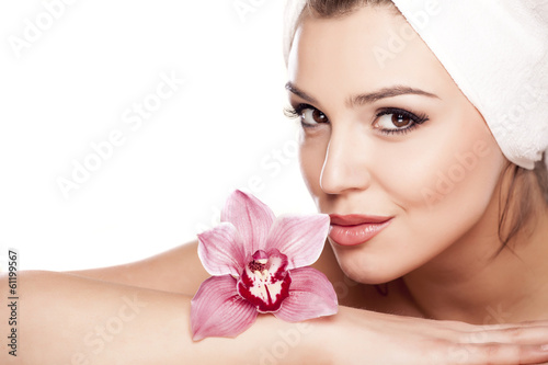  woman with a towel on her head enjoying the scent of orchids