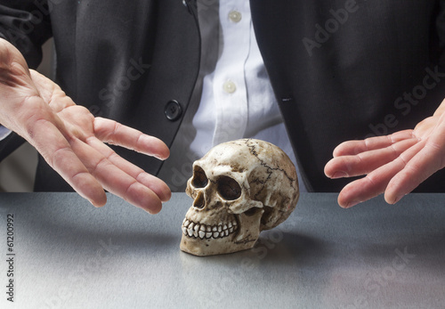 Photo: male hands presenting a skull for scientific purpose male hands presenting a skull for scientific purpose