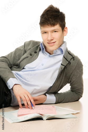 Photo: A young handsome college guy lying on the floor. A young handsome college guy lying on the floor.