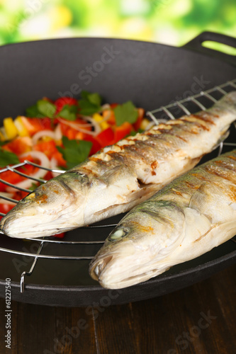 Photo: Delicious grilled fish on wok close-up Delicious grilled fish on wok close-up