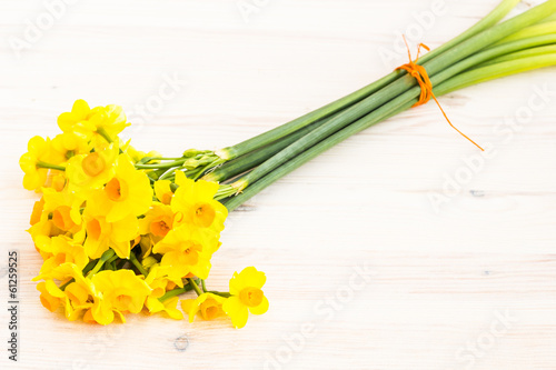 Photo: Bouqut of yellow lent lilyl (daffodil) on a wooden table Bouqut of yellow lent lilyl (daffodil) on a wooden table