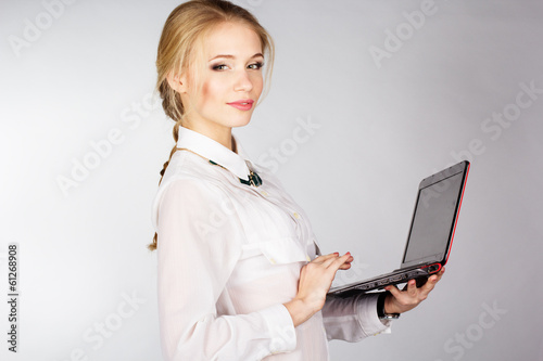 Photo: Portrait of woman with a laptop over white background Portrait of woman with a laptop over white background