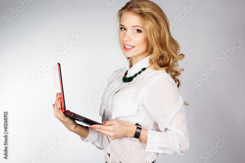 Photo: Portrait of woman with a laptop over white background Portrait of woman with a laptop over white background