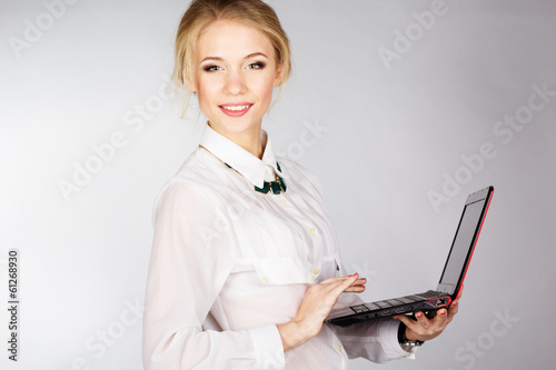 Photo: Portrait of woman with a laptop over white background Portrait of woman with a laptop over white background