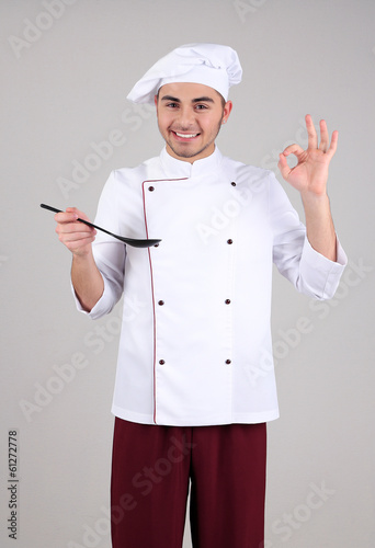 Photo: Professional chef in white uniform and hat, on gray background Professional chef in white uniform and hat, on gray background