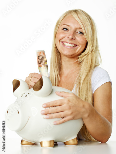 Photo: Pretty girl puts euro notes in her piggy bank Pretty girl puts euro notes in her piggy bank