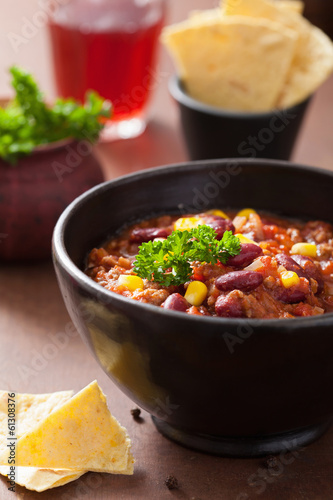 Photo: mexican chili con carne in black plate with tortilla mexican chili con carne in black plate with tortilla