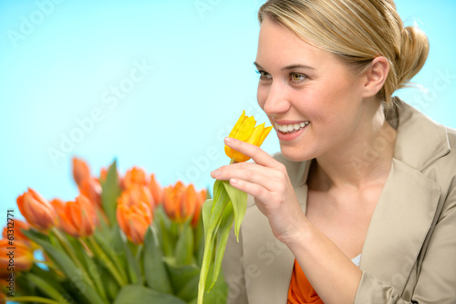 Photo: Woman smelling one yellow tulip spring flowers Woman smelling one yellow tulip spring flowers