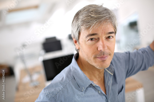Photo: Mature businessman standing in office Mature businessman standing in office