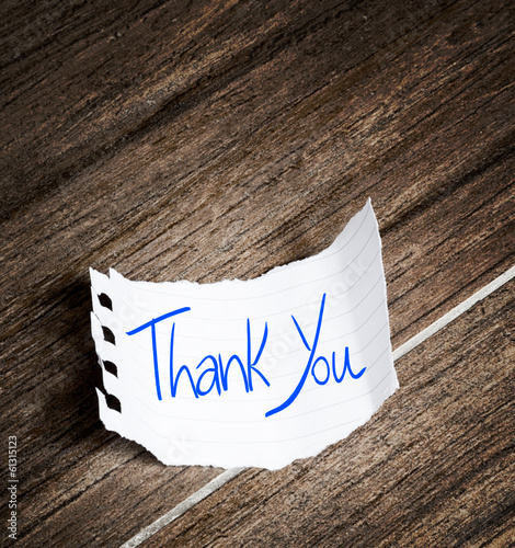 Photo: Thank You written on the paper on a wood background Thank You written on the paper on a wood background