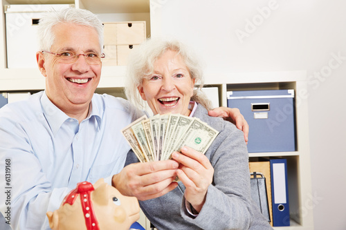 Photo: Senior couple with dollar and piggy bank Senior couple with dollar and piggy bank