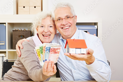 Photo: Happy elderly couple with Euro money and house Happy elderly couple with Euro money and house