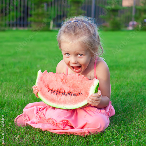 Photo: Little adorable girl with a piece of watermelon in hands Little adorable girl with a piece of watermelon in hands
