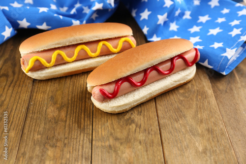 Photo: Tasty hot dogs on wooden table Tasty hot dogs on wooden table
