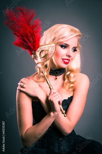 Photo: junge blonde Frau mit venezianischer Stabmaske junge blonde Frau mit venezianischer Stabmaske
