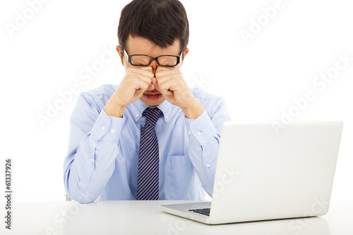 Photo: tired young businessman rubbing his eyes tired young businessman rubbing his eyes