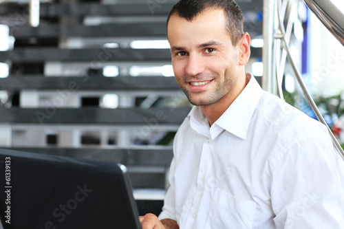 Photo: Businessman sitting on stairs and using laptop pc. Businessman sitting on stairs and using laptop pc.