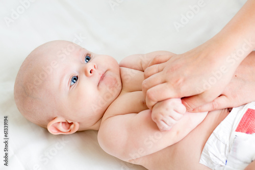 Photo: mother or masseur does gymnastic to kid mother or masseur does gymnastic to kid
