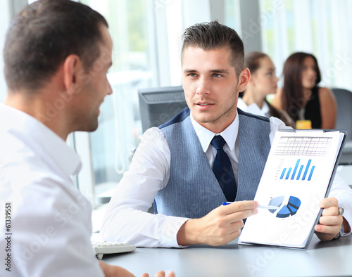 Photo: Happy business people talking on meeting at office Happy business people talking on meeting at office