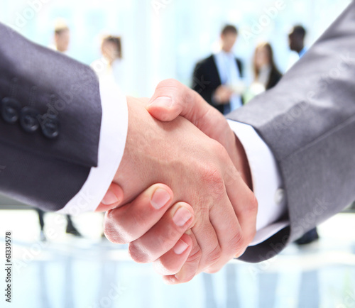 Photo: Closeup of business people shaking hands over a deal Closeup of business people shaking hands over a deal