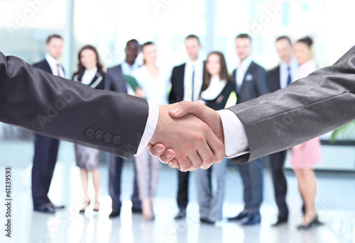 Photo: Closeup of business people shaking hands over a deal Closeup of business people shaking hands over a deal