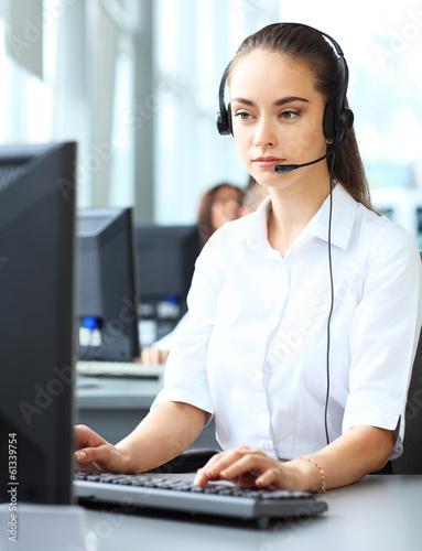 Photo: Female customer support operator with headset and smiling Female customer support operator with headset and smiling