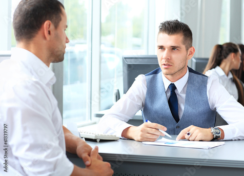 Photo: Happy business people talking on meeting at office Happy business people talking on meeting at office