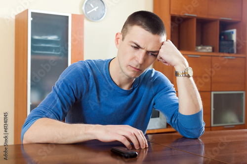 Photo: Young guy at table in home Young guy at table in home