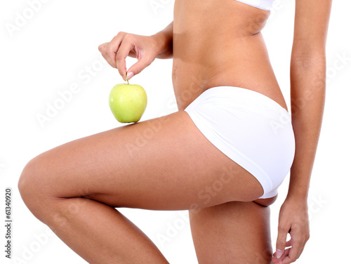 Photo: Beautiful young woman with green apple isolated on white Beautiful young woman with green apple isolated on white