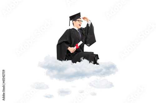 Photo: Male college graduate seated on cloud and looking in distance Male college graduate seated on cloud and looking in distance