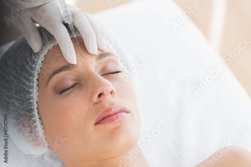Photo: Woman recieving botox injection in forehead Woman recieving botox injection in forehead