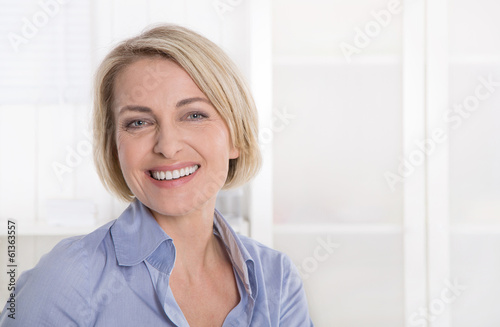 Photo: Ältere schöne blonde Frau - Portrait mit Hintergrund weiß blau Ältere schöne blonde Frau - Portrait mit Hintergrund weiß blau