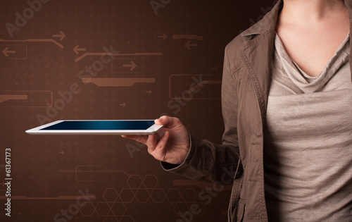 Photo: Woman holding a white tablet with blurry apps Woman holding a white tablet with blurry apps