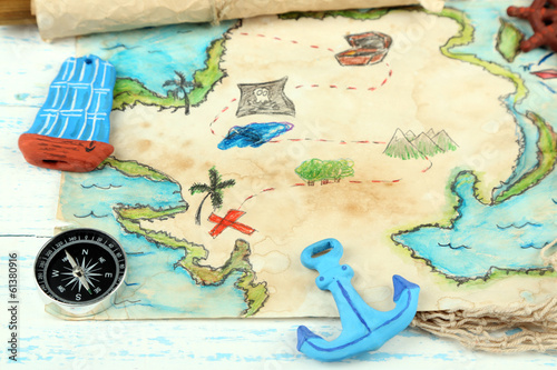 Photo: Treasure map with sea accessories, on wooden background Treasure map with sea accessories, on wooden background