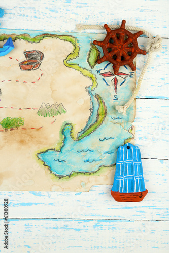 Photo: Treasure map with sea accessories, on wooden background Treasure map with sea accessories, on wooden background