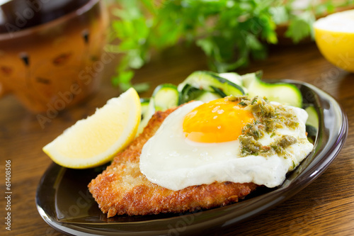 Photo: Wiener schnitzel with fried egg and capers. Wiener schnitzel with fried egg and capers.
