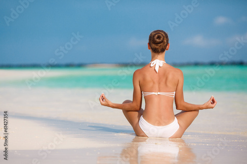Photo: Portrait of a young woman doing yoga on a tropical beach Portrait of a young woman doing yoga on a tropical beach