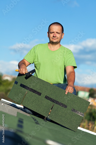 Photo: Roofer on top of building Roofer on top of building