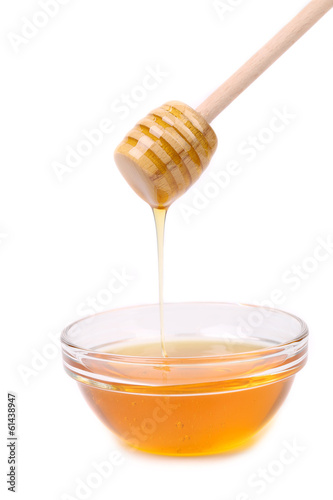 Photo: Honey dripping from a wooden dipper. Honey dripping from a wooden dipper.
