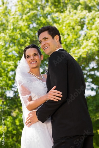 Photo: Romantic newlywed couple standing in park Romantic newlywed couple standing in park