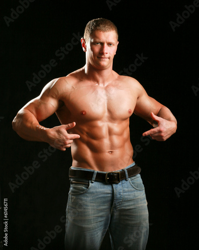 Photo: Healthy muscular young man. Isolated on black background Healthy muscular young man. Isolated on black background