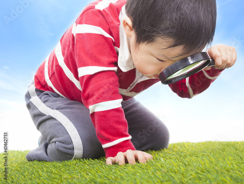 Photo: a boy exploring nature with magnifying glass a boy exploring nature with magnifying glass