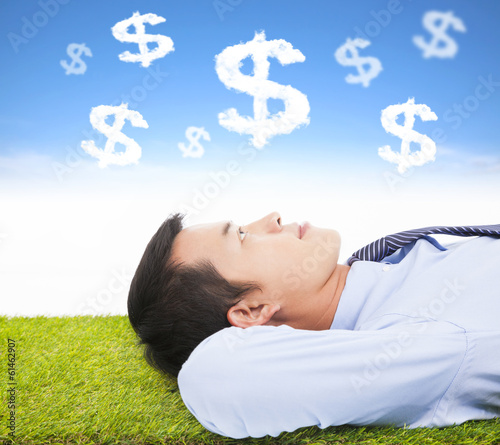 Photo: businessman thinking money and goal on a meadow businessman thinking money and goal on a meadow
