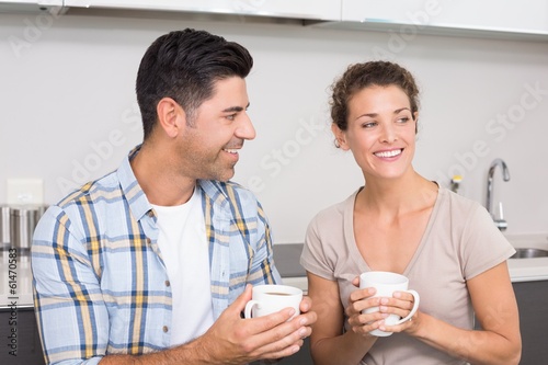 Photo: Attractive couple sitting having coffee together Attractive couple sitting having coffee together