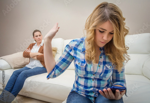 Photo: Daughter looking a phone and ignoring her mother Daughter looking a phone and ignoring her mother