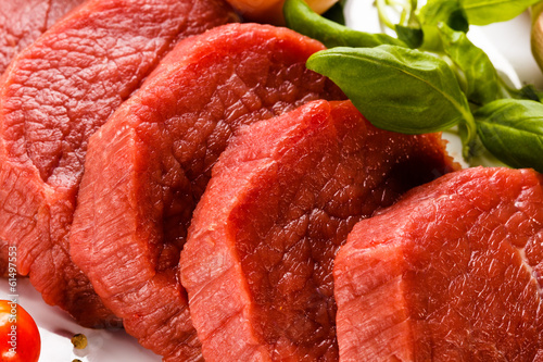 Photo: Raw beef and vegetables on white background Raw beef and vegetables on white background